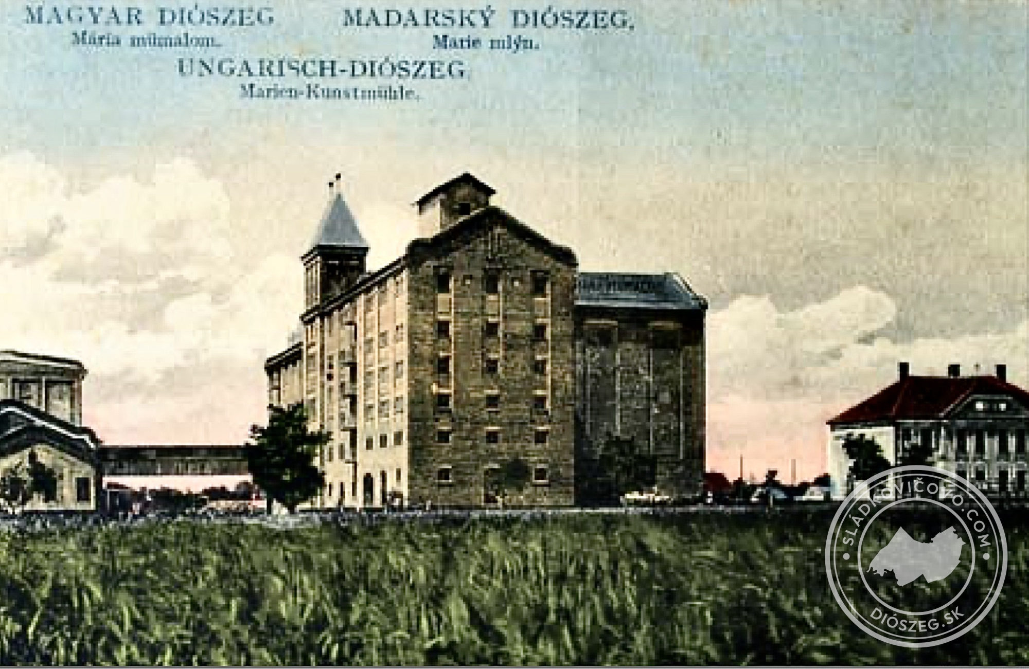 Mária mümalom na Košútskej ceste v dvadsiatych rokoch 20. storočia na kolorovanej pohľadnici. Na pravej strane fotografie je budova so služobnými bytmi.